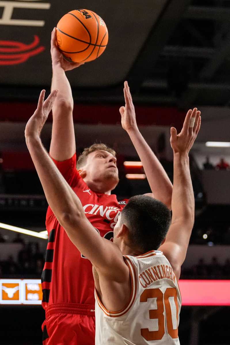 Cincinnati Bearcats forward Viktor Lakhin (30) rises above Texas Longhorns forward Brock Cunningham (30) in the first half of the NCAA Big 12 basketball game between the Cincinnati Bearcats and the Texas Longhorns at Fifth Third Arena in Cincinnati on Tuesday, Jan. 9, 2024.